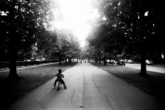 Long allée menant à un parc, un enfant fait du vélo - Bruxelles 2017